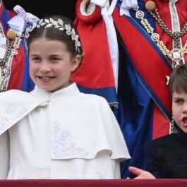 Prințesa Charlotte alături de Prințul Louis în timp ce fac cu mâna de la balconul Palatului Buckingham în ziua Încoronării Regelui Charles