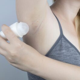 O femeie care se dă cu deodorant și are axila iritată