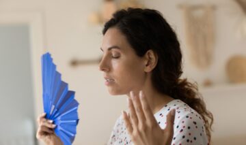 O femei care se confruntă cu bufeuri în timpul apariției menopauzei