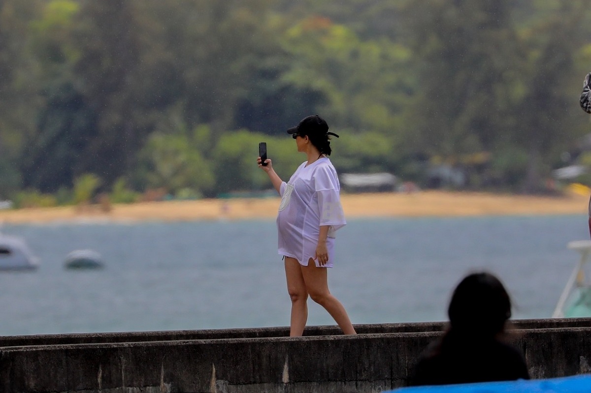 Kourtney Kardashian într-un tricou alb în timp ce se plimbă pe plajă