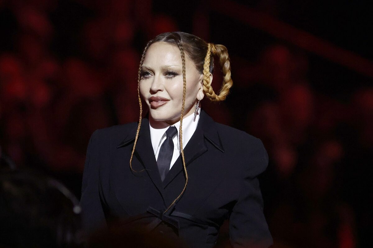 Madonna într-un costum negru și cu părul prins în cozi în timpul unui eveniment public