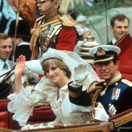 Prințul Charles și Prințesa Diana în timp ce fac cu mâna mulțimii din caleașca regală după ce s-au căsătorit