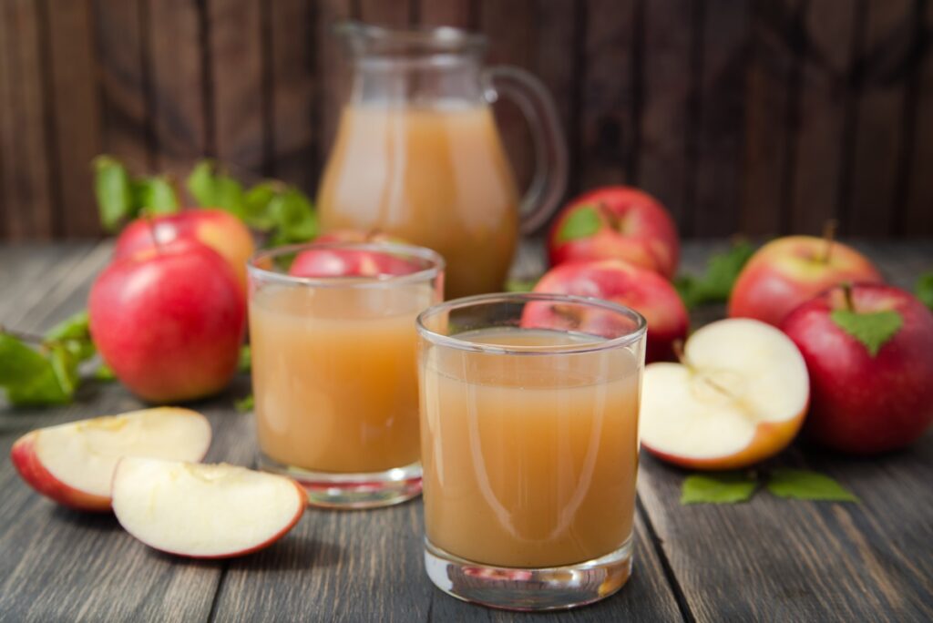 Suc concentrat de mere în pahare și în borcan, alături de mere proaspete