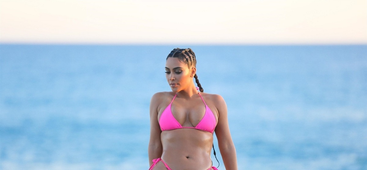 Kim Kardashian într-un cosltum de baie roz în timp ce se relaxează în piscină