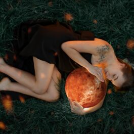 O femeie frumoasă care ține în brațe o reprezentare a planetei Venus care intră în retrograd pe 22 iulie 2023