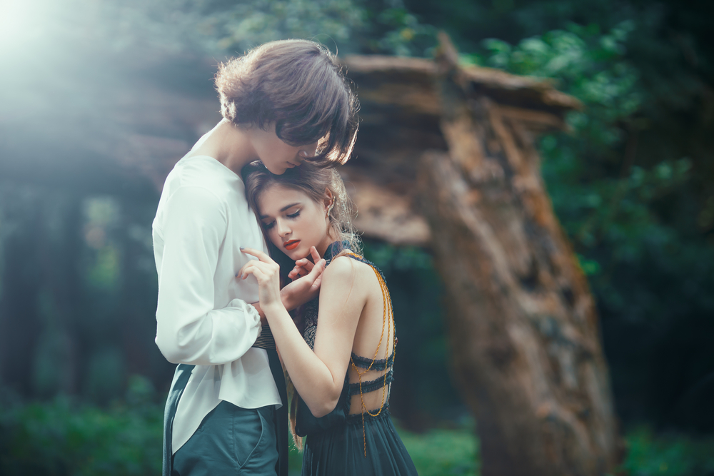 Îndrăgostiți care se țin în brațe într-o pădure, romantici