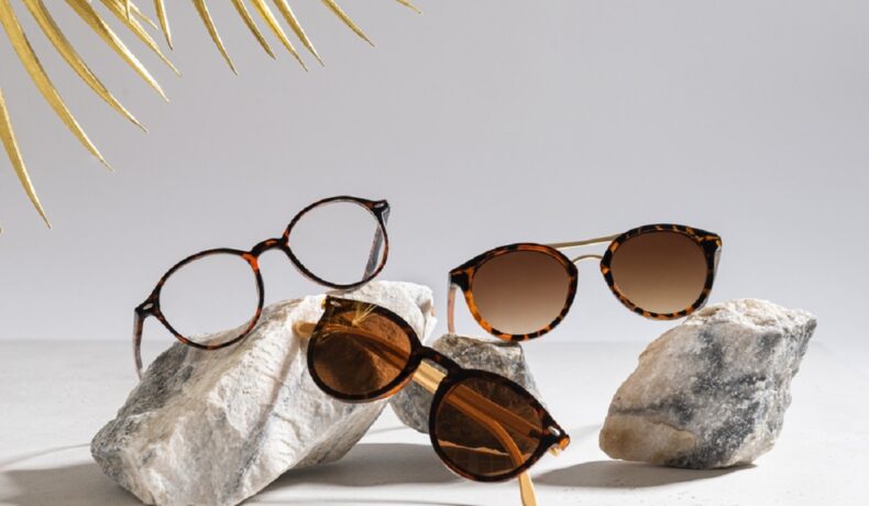 Trei perechi de ochelari de soare diferiți așezați pe trei pietre decorative