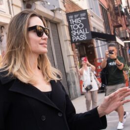 Angelina Jolie are un outfit negru la care și-a pus ochelari de soare clasici, negri și a fost întâmpinată de jurnaliști și paparazzi pe o stradă din New York City
