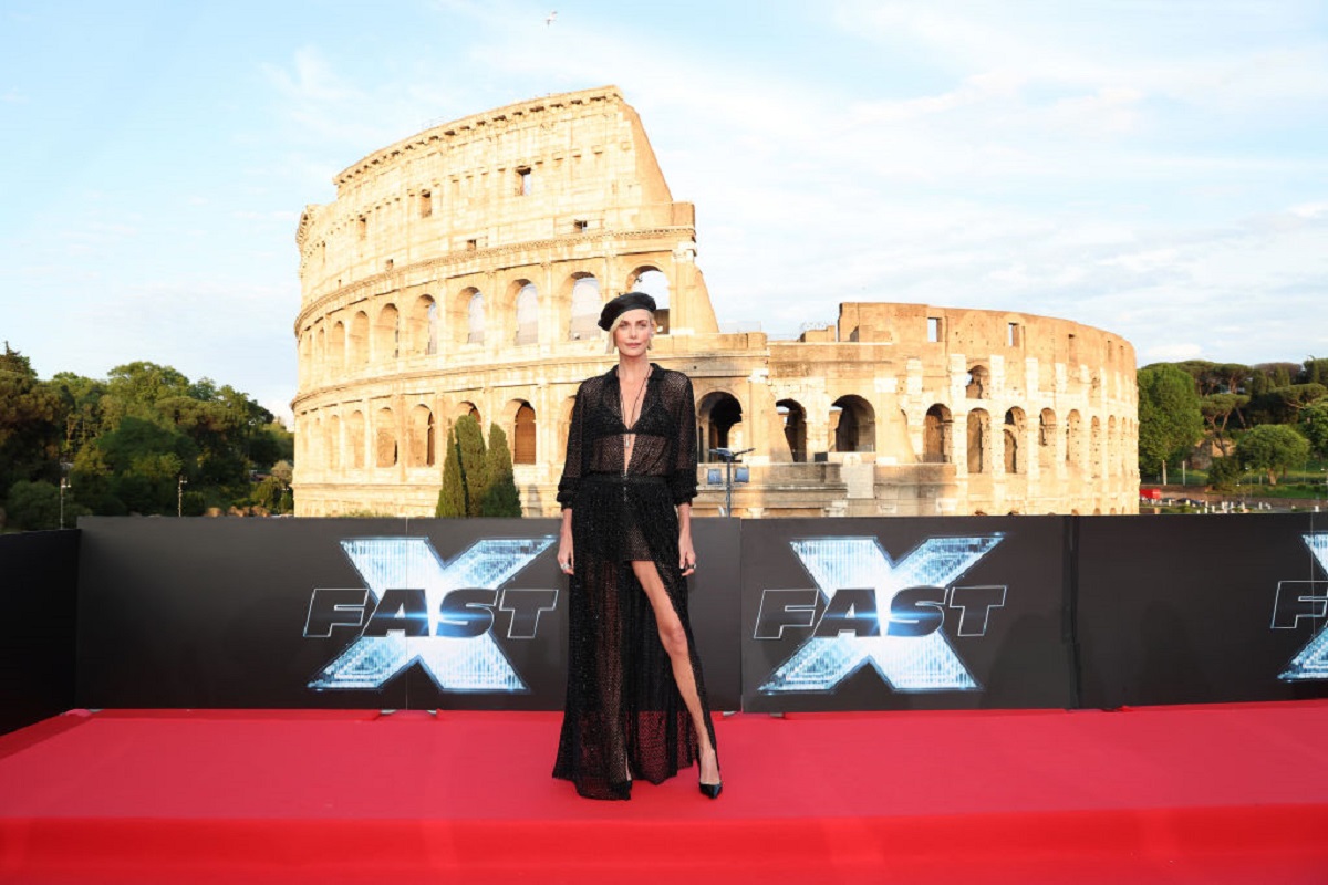 Îmbrăcată cu un outfit negru, sexy și transparent, Charlize Theron pozează pe covorul roșu întins pentru lansarea filmului „FAST X Road To Rome”, care a avut loc lângă Colosseumul din Roma, Italia