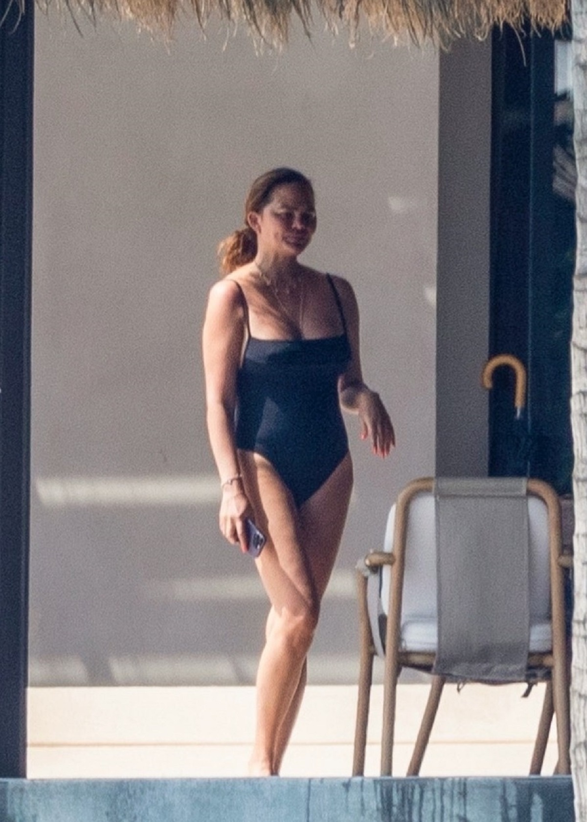 Chrissy Teigen într-un costum de baie negru în timp ce se relaxează în vacanța din Mexic