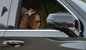 Jennifer Lopez cu ochelari de soare la ochi pe scaunul din dreapta al unei mașini