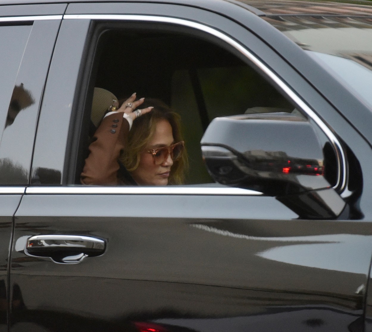 Jennifer Lopez cu ochelari de soare la ochi pe scaunul din dreapta al unei mașini