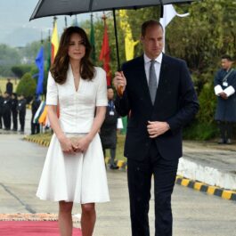 În timp ce Kate Middleton a purtat un taior alb, Prințul William a îmbrăcat un costum negru, cămașă albă și o cravată la plecarea de pe Aeroportul Internațional Paro, Bhutan, care a avut loc pe 16 aprilie 2016