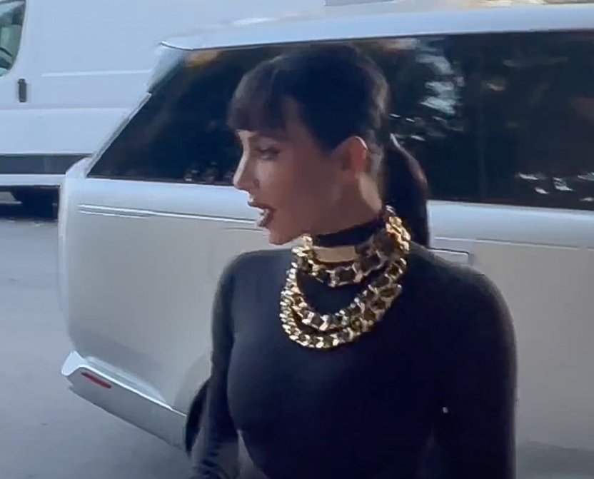 Kim Kardashian, într-o rochie neagră, cu mai multe coliere groase la gât, din aur