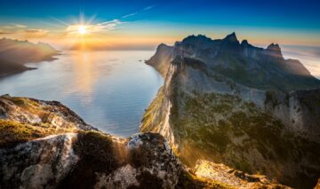 Poză realizată din vârful Segla și se văd munții, dar și Soarele care strălucește puternic pe cerul Norvegiei