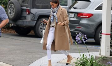 Meghan Markle, într-o pereche de jeanși albi, cu un palton bej, pe stradă
