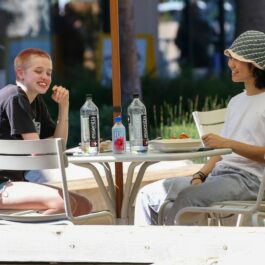 Shiloh Jolie-Pitt, în tricou și pantaloni scurți, la o masă la restaurant