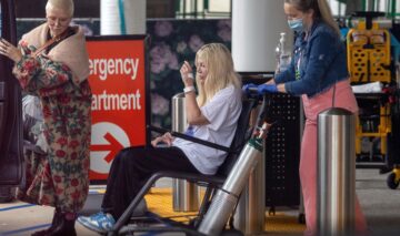 Tori Spelling, într-un scaun cu rotile, în timp ce este ajutată de o asistentă să se deplaseze