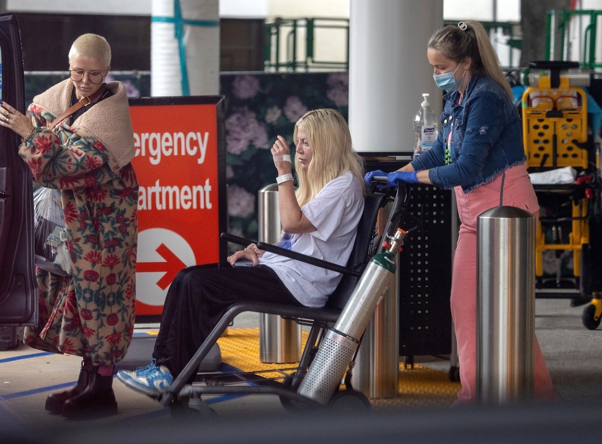 Tori Spelling, într-un scaun cu rotile, în timp ce este ajutată de o asistentă să se deplaseze