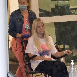 Tori Spelling în timp ce este scoasă din spital de o asistentă cu ajutorul unui cărucior cu rotile