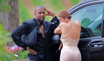 Kanye West, într-un costum negru,, alături de Bianca Censori, într-un costum nude, în timp ce stau de vorbă