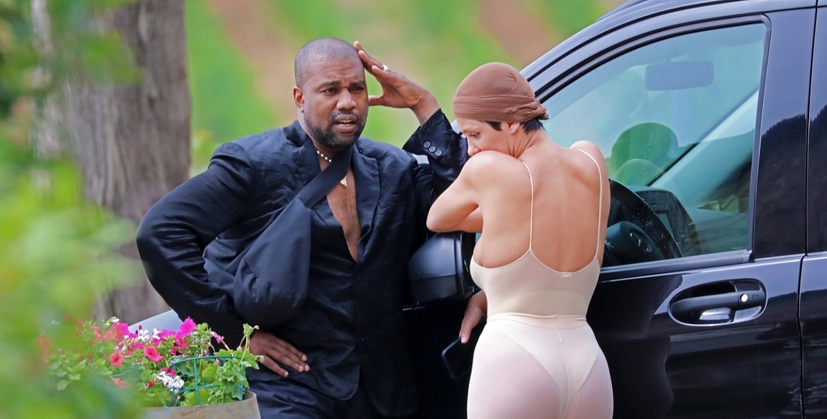 Kanye West, într-un costum negru,, alături de Bianca Censori, într-un costum nude, în timp ce stau de vorbă