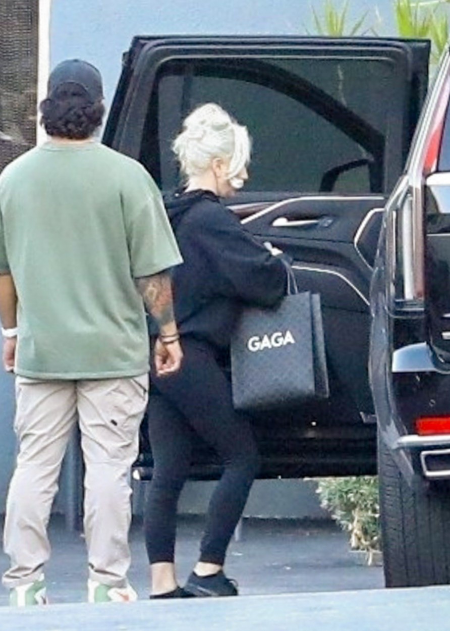 Lady Gaga, în colanți negri, un hanorac, cu părul prins lejer, într-o parcare