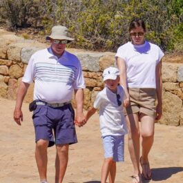 Prințul Albert, în pantaloni scurți, de mână cu unul dintre copii, în vacanță
