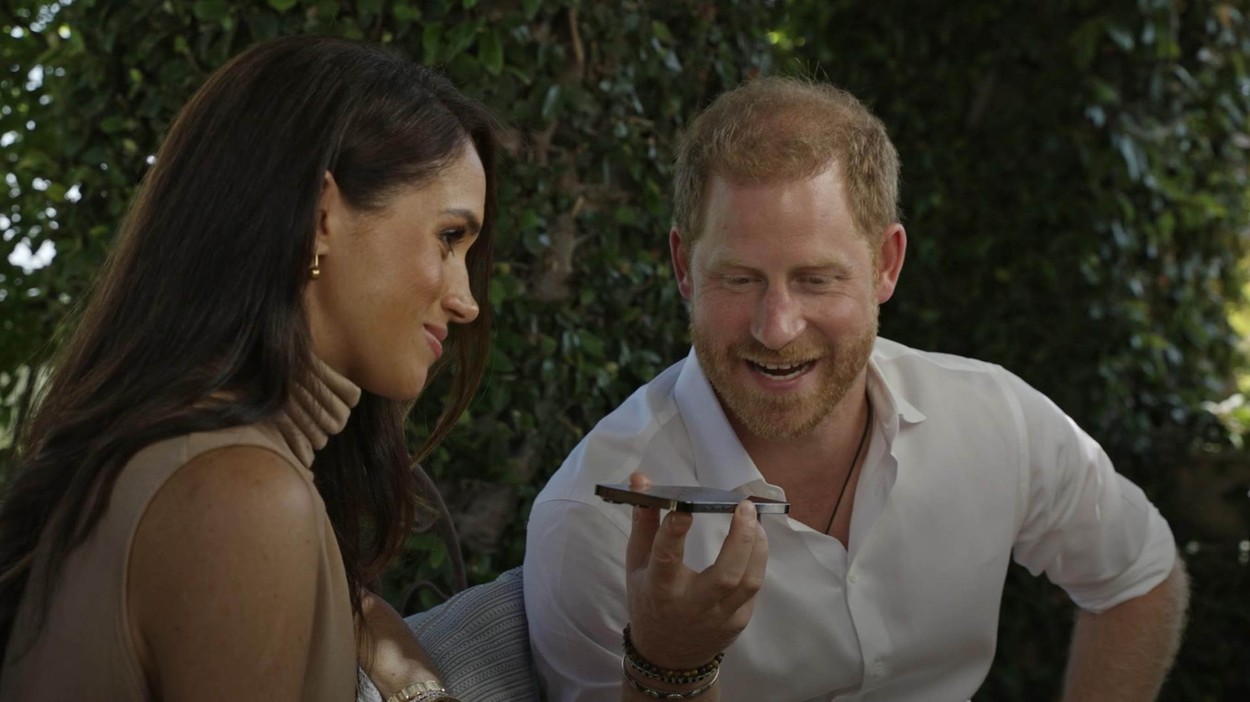 Prințul Harry ține un telefon în mână și vorbește cu beneficiarii unui grant pentru tehnologie