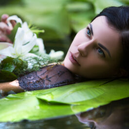 O femeie care stă pe gânduri, cufundată într-o apă cu nuferi