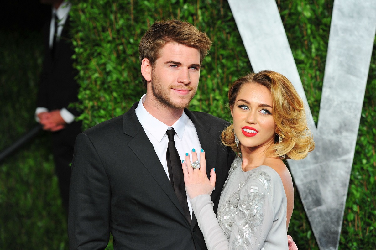 Miley Cyrus și Liam Hemsworth în timp ce pozează împreună la Vanity Fair 2012