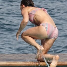 Pippa Middleton într-un costum de baie roz surprinsă de la spate în timp ce iese din apă