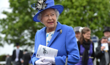 Regina Elisabeta, într-un costum de culoare albastru, asortat cu mănuși albe