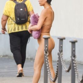 Bianca Censori într-o ținută nude în timp ce își acoperă bustul cu o pernă