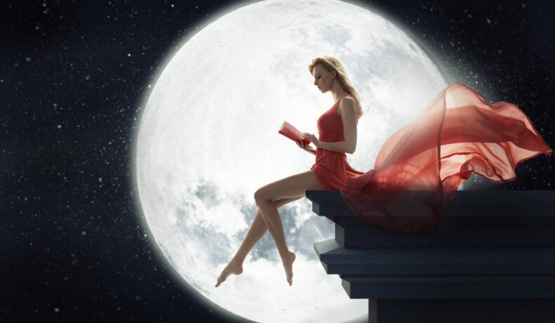 O femeie frumoasă care poartă o rochie roșie și citește pentru a ilustra ce e recomandat să faci atunci când este Lună Nouă