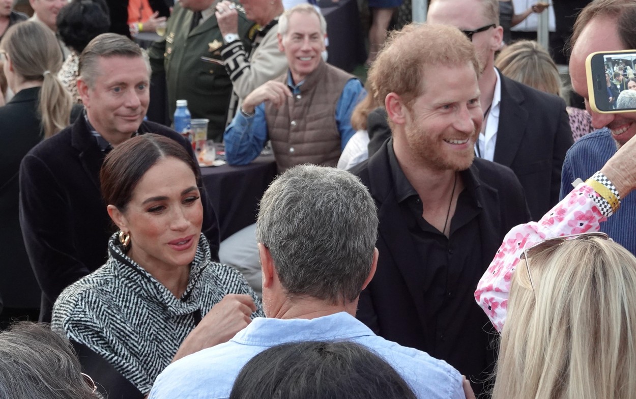 Meghan Markle și Prințul Harry, la un eveniment caritabil, în timp ce discută cu fanii
