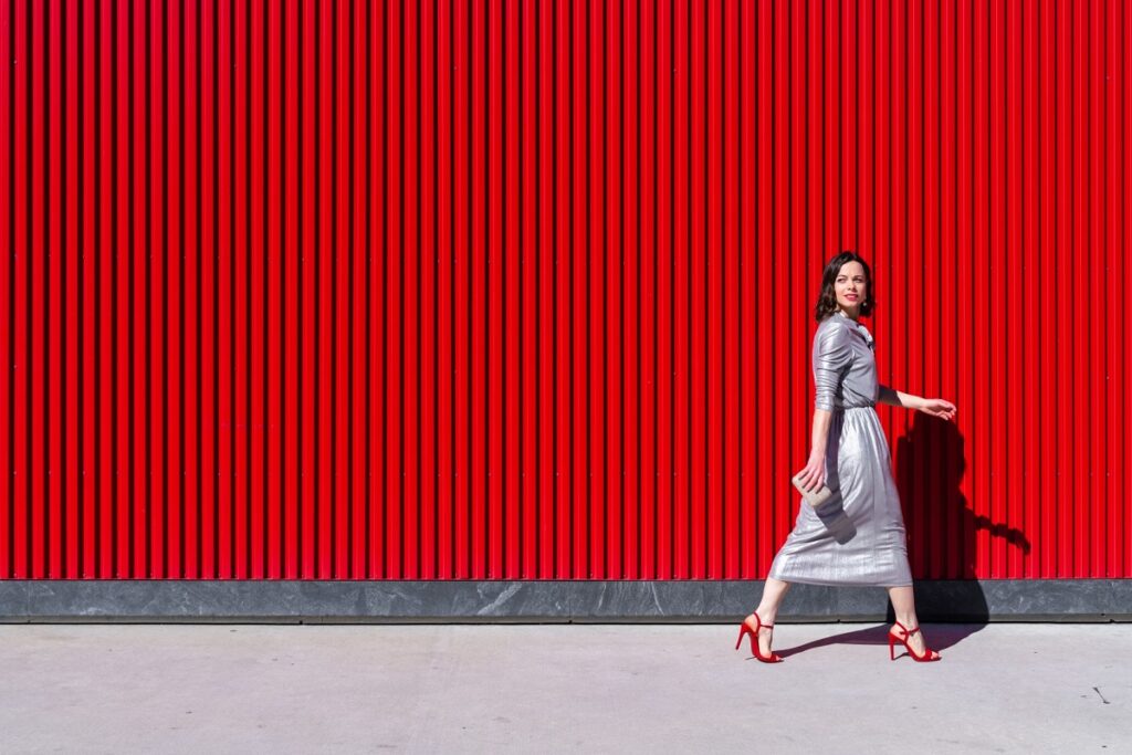 O femeie frumoasă care paortă o pereche de pantofi roși
