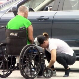 Jennifer Garner, lângă un bărbat în scaun cu rotile, fotografiată în timp ce încearcă să-l încalțe