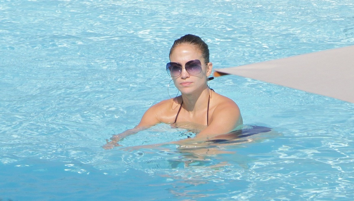 Jennifer Lopez în timp ce poartă costum de baie și înoată într-o piscină