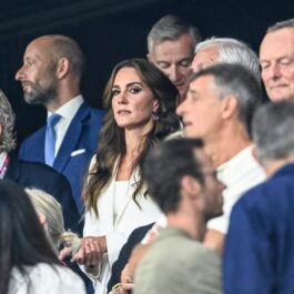 Kate Middleton, într-un costum alb, cu părul coafat în bucle lejere