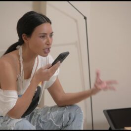 Kim Kardashian, în tricou și blugi, în timo ce vorbește la telefon