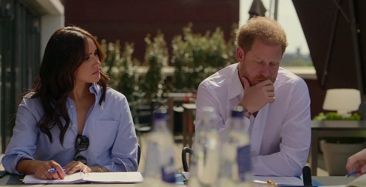 Meghan Markle și Prințul Harry în timp ce stau împreună la o masă și discută