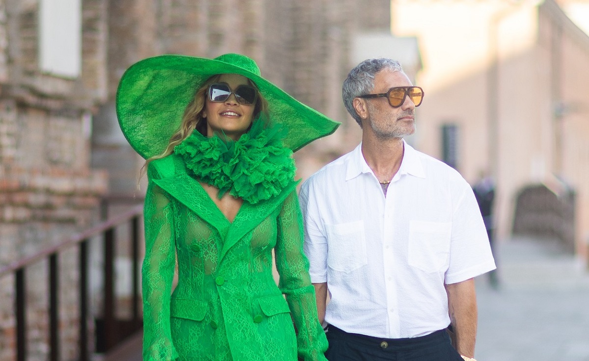Rita Ora într-un costum verde alături de Taika Waititi, la cămașă albă, în timp ce se plimbă prin Veneția