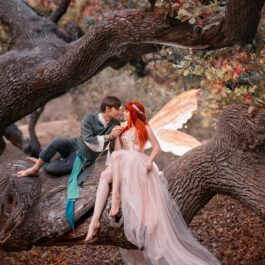 Un cuplu cu doi îndrăgostiți care stau pe un copac și se sărută pentru a ilustra cele trei zodii care își găsesc dragostea până la sfârșitul lunii septembrie