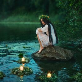 O femeie frumoasă care stă pe marginea unui lac și privește niște lumânări pentru a ilustra una dintre cele trei zodii care nu uită cu ușurință