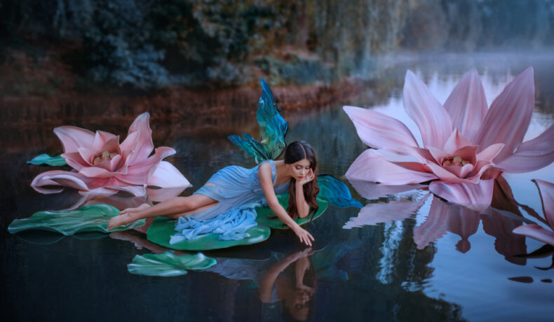 O femeie îmbrăcată în zână, pe o frunză de nufăr, pe un lac