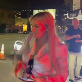 Britney Spears, într-o cămașă albă, într-o parcare, noaptea