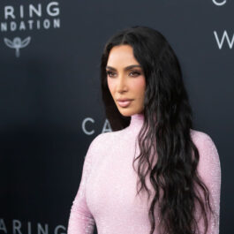 Kim Kardashian, într-o rochie roz, la un eveniment, fotografie la panou