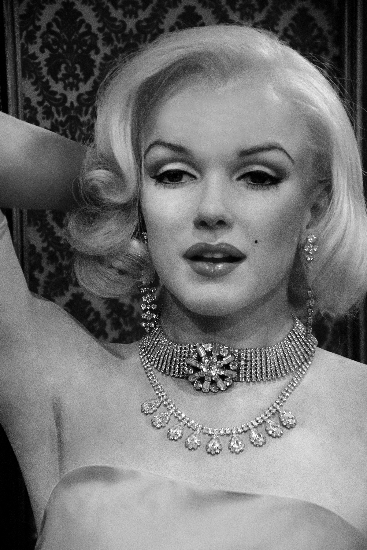Marilyn Monroe într-o fotografie alb0negru, cu un somptuos colier de diamante la gât și cercei cu diamante
