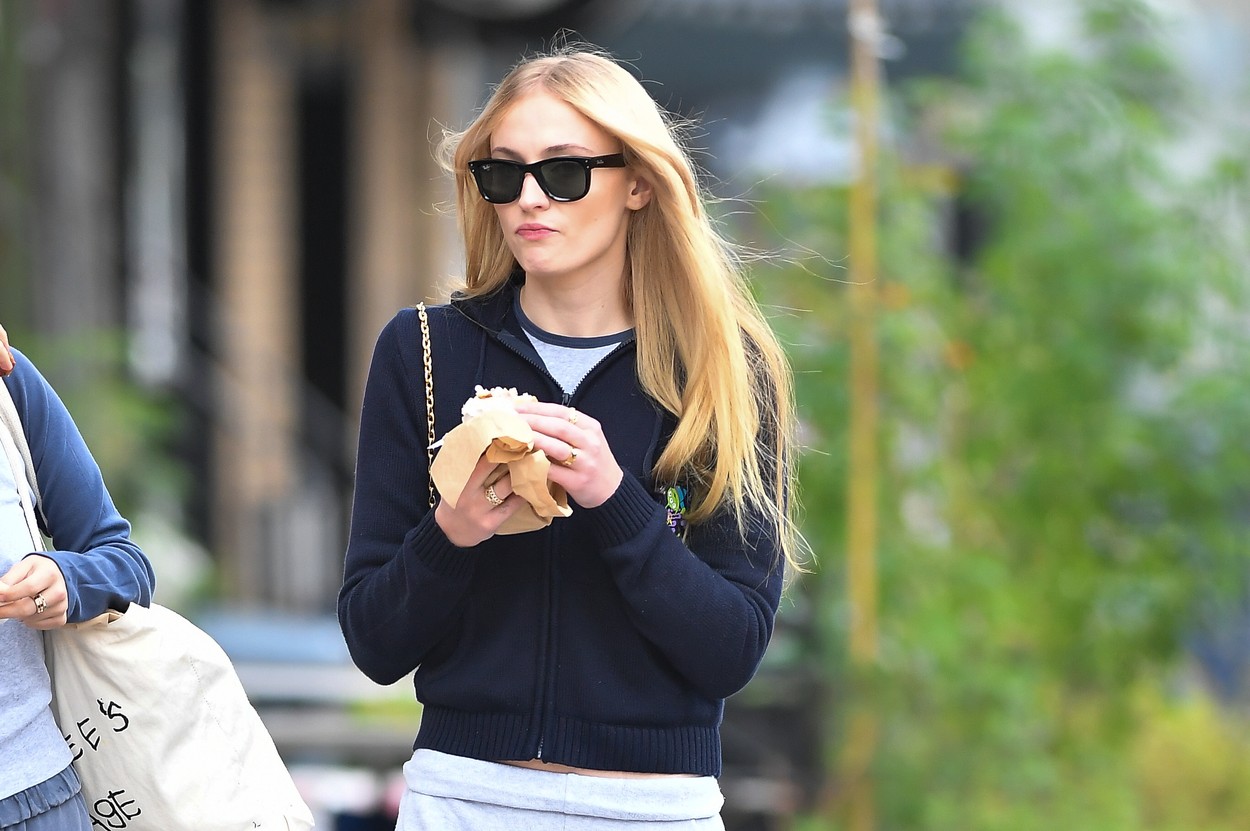 Sophie Turner, pe stradă, cu mâncare în mână, în haine casual